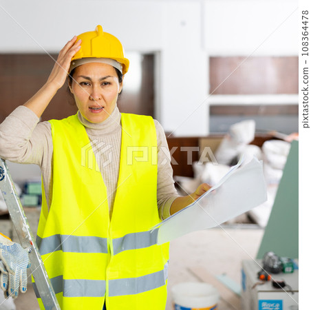 Woman builder checking project documentation 108364478