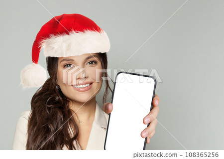 Happy Christmas businesswoman holding smartphone with blank empty display screen 108365256