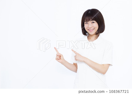 A nurse in her 30s giving an introduction in front of a white background 108367721