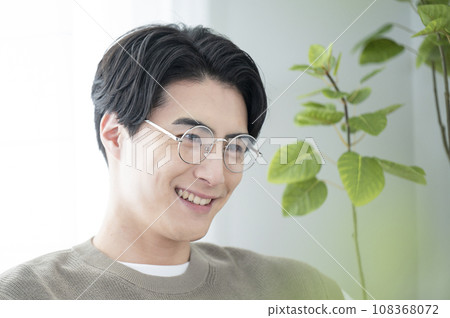 一個戴眼鏡的男人在客廳放鬆的特寫 108368072