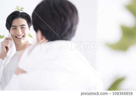 A refreshing man brushing his teeth A refreshing man brushing his teeth 108368856