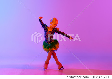 Beautiful, adorable little girl, child in stage costume dancing, performing figure skating against gradient pink purple background in neon light Beautiful, adorable little girl, child in stage costume dancing, performing figure skating against gradient pink purple background in neon light 108371211