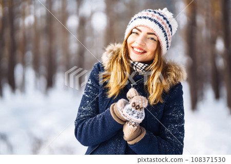 Portrait of young beautiful girl with long hair, in a blue jacket. Fashion woman in winter forest. 108371530