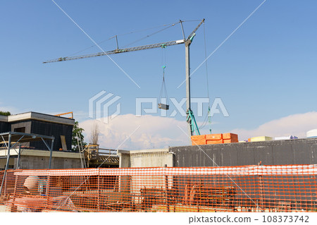Crane tower on a residential building construction site. Crane tower on a residential building construction site. 108373742