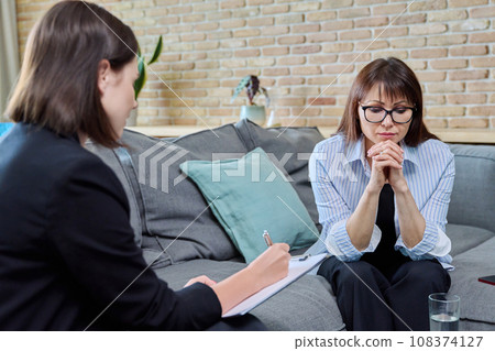 Middle aged sad woman at mental therapy in modern office, talking to psychologist Middle aged sad woman at mental therapy in modern office, talking to psychologist 108374127