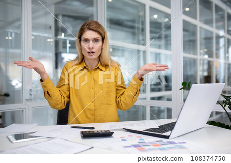 Frustrated and sad workplace woman inside office workplace looking at camera, businesswoman unhappy with work and achievement results, nervous working with laptop. 108374750