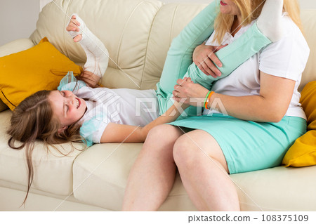 Child with broken arm and gypsum spend time at home with mother. Childhood illnesses, a positive outlook and recovery. Child with broken arm and gypsum spend time at home with mother. Childhood illnesses, a positive outlook and recovery. 108375109