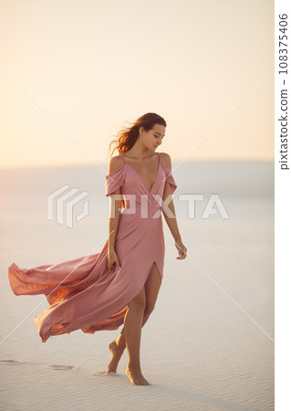 Walking in Desert Fashionable Woman Model in Evening Pink Dress Walking in Desert Fashionable Woman Model in Evening Pink Dress 108375406