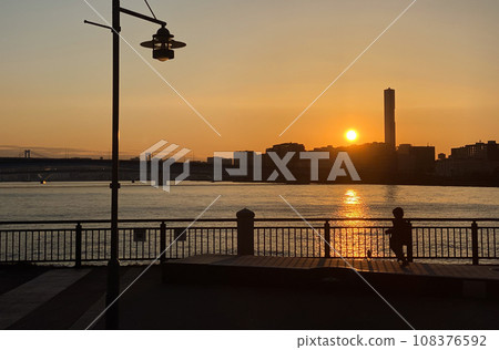 Silhouette of a child against the backdrop of the setting sun Silhouette of a child against the backdrop of the setting sun 108376592