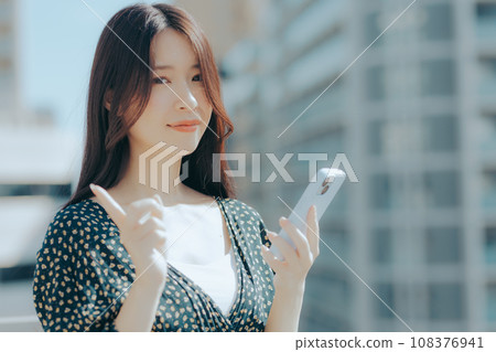 一名年輕女子拿著智慧型手機的場景 一名年輕女子拿著智慧型手機的場景 108376941