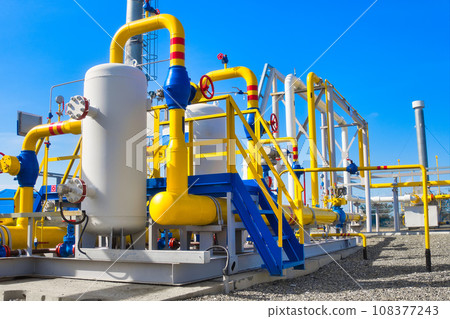 Gas distribution station. Industrial facility. Gas processing station with yellow pipes on a summer 108377243