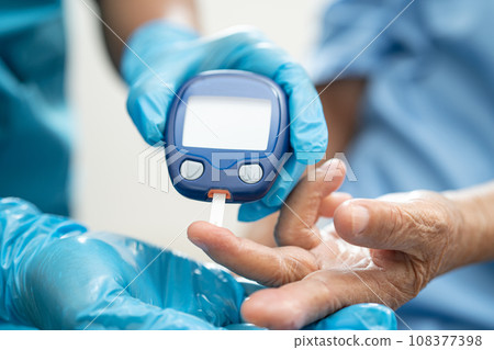 Doctor check diabetes from finger blood sugar level with finger lancet. 108377398