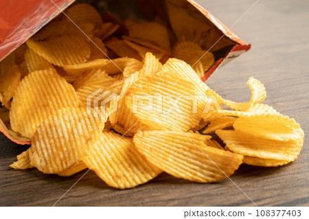 Potato chips, delicious BBQ seasoning spicy for crips, thin slice deep fried snack fast food in open bag. Potato chips, delicious BBQ seasoning spicy for crips, thin slice deep fried snack fast food in open bag. 108377403