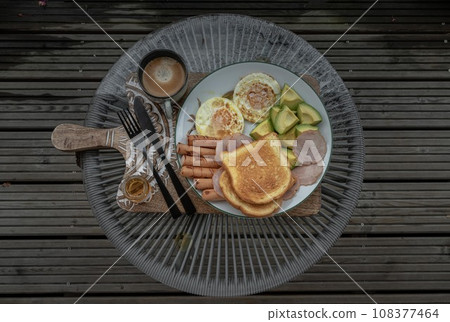 breakfast is including Fried sausages, Fried eggs, Toast breads and cut avocados served with Honey and Cup of coffee. breakfast is including Fried sausages, Fried eggs, Toast breads and cut avocados served with Honey and Cup of coffee. 108377464