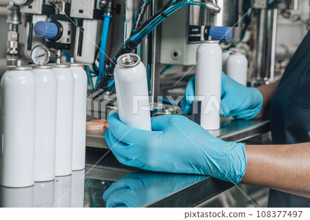 Filling of tin packages for spray with cosmetics in production Filling of tin packages for spray with cosmetics in production 108377497