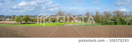 Extra large panoramic view over the brown soil, green fields and trees at the Flemish countryside around Gooik, Belgium 108378293