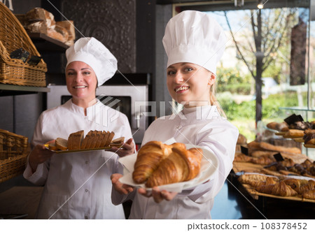 Women workers in a bakery posing with pastries Women workers in a bakery posing with pastries 108378452