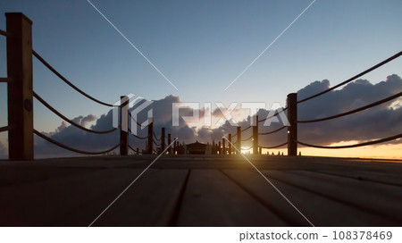 Sunrise over wooden pier by the ocean 108378469
