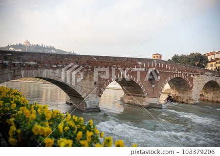 An arched bridge over flowing water - italian medieval landscape 108379206