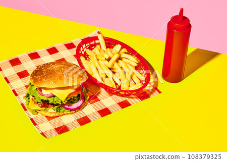 Delicious burger, hamburger with meat, cheese, lettuce and tomato with fries and ketchup on napkin over yellow background. Fast food, junk food, taste. Poster 108379325