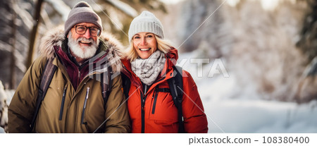 Banner with a couple of adults taking a walk through a beautiful winter forest, outdoor recreation in the forest. Free space for text, invitation to Christmas and New Year holidays in nature 108380400
