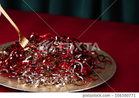 Creative New Year food, New Year party concept. Christmas tinsel on a plate like spaghetti. Creative New Year food, New Year party concept. Christmas tinsel on a plate like spaghetti. 108380771