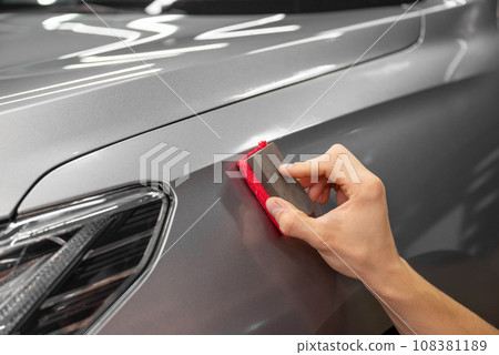 specialist in the salon waxes the client's car. Polishing the car body specialist in the salon waxes the client's car. Polishing the car body 108381189
