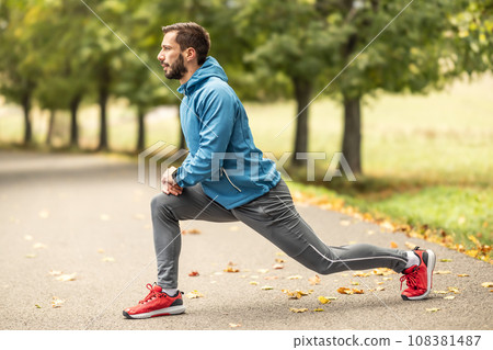 A young athlete is warming up before running training in the park 108381487