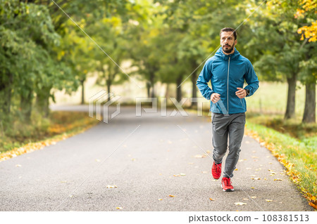 A young man is training and running in an autumn park. A young man is training and running in an autumn park. 108381513