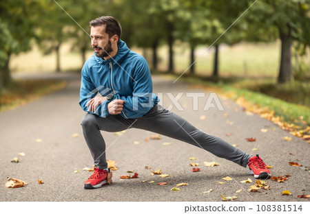 A young athlete is warming up before running training in the park 108381514