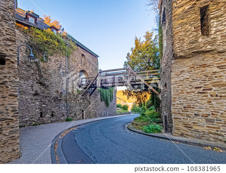 Image of a road along the outer wall of a historical castle with wooden bridge Image of a road along the outer wall of a historical castle with wooden bridge 108381965