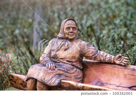 Valga, Estonia - October 22, 2023: Public bus waiting stops. Wooden sculptures as benches. Valga, Estonia - October 22, 2023: Public bus waiting stops. Wooden sculptures as benches. 108382001
