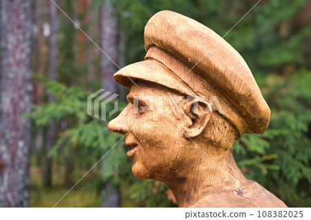 Valga, Estonia - October 22, 2023: Public bus waiting stops. Wooden sculptures, human silhouette profile Valga, Estonia - October 22, 2023: Public bus waiting stops. Wooden sculptures, human silhouette profile 108382025