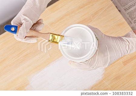 white paint with a brush painting a wooden background with texture white paint with a brush painting a wooden background with texture 108383332