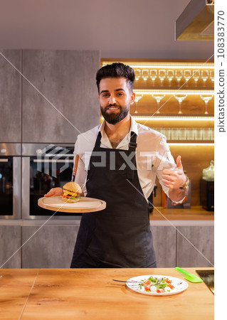 Portrait happy chef with cooked meals for a dinner party in the kitchen copy space and empty space for text Portrait happy chef with cooked meals for a dinner party in the kitchen copy space and empty space for text 108383770
