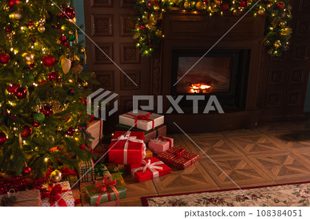 Classical Christmas decorated interior living room library with fireplace. Christmas tree with red golden ornament decorations. Modern classic style interior design apartment. Christmas eve at home 108384051