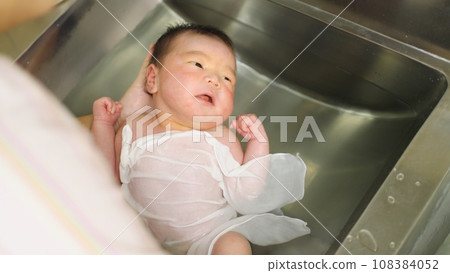 Mother receiving bathing instruction at maternity hospital Mother receiving bathing instruction at maternity hospital 108384052