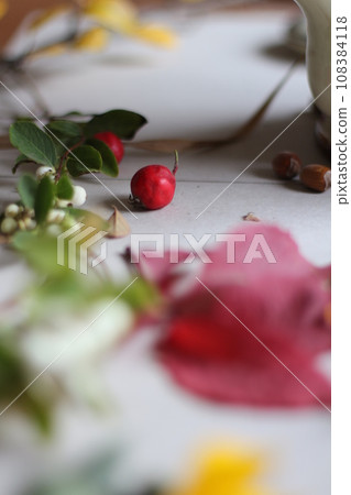 Hawthorn berries and leaves on a white paper. Selective focus. Hawthorn berries and leaves on a white paper. Selective focus. 108384118
