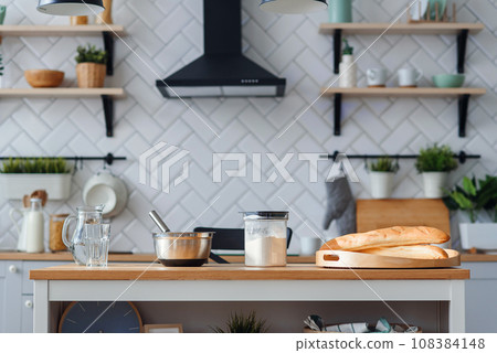 Kitchen utensils for dough preparation. A bank with water, a metal plate and a flour. 108384148