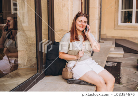 Casual communication in cafe female woman smiling positive conversation talking to her friend. Beautiful woman on phone sitting on terrace. 108384676