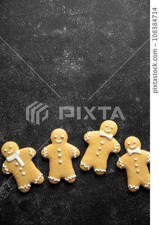 Christmas gingerbread man cookies over dark background, copy space. Christmas gingerbread man cookies over dark background, copy space. 108384714