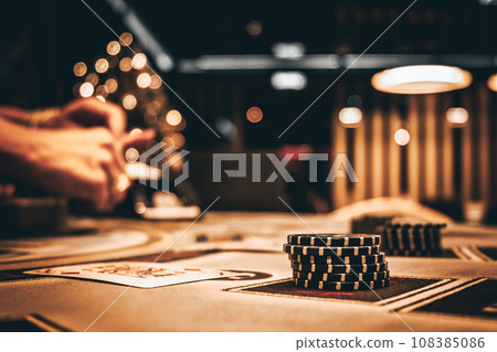 Dealer or croupier shuffles poker cards in a casino on the background of a table, chips. Concept of poker game, game business. Playing for money, a big win, a jackpot, gambling, a desire to get rich. Dealer or croupier shuffles poker cards in a casino on the background of a table, chips. Concept of poker game, game business. Playing for money, a big win, a jackpot, gambling, a desire to get rich. 108385086