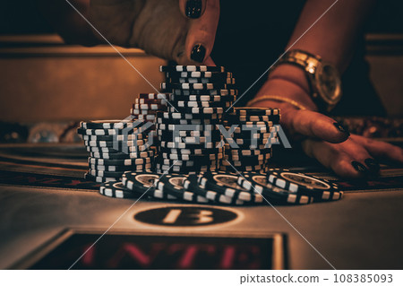 Dealer or croupier shuffles poker cards in a casino on the background of a table, chips. Concept of poker game, game business. Playing for money, a big win, a jackpot, gambling, a desire to get rich. 108385093
