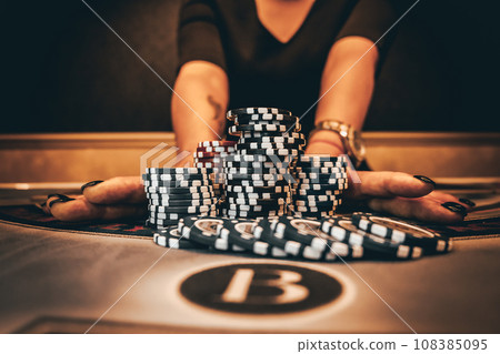 Dealer or croupier shuffles poker cards in a casino on the background of a table, chips. Concept of poker game, game business. Playing for money, a big win, a jackpot, gambling, a desire to get rich. 108385095