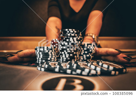 Dealer or croupier shuffles poker cards in a casino on the background of a table, chips. Concept of poker game, game business. Playing for money, a big win, a jackpot, gambling, a desire to get rich. Dealer or croupier shuffles poker cards in a casino on the background of a table, chips. Concept of poker game, game business. Playing for money, a big win, a jackpot, gambling, a desire to get rich. 108385096