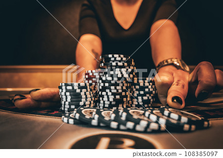 Dealer or croupier shuffles poker cards in a casino on the background of a table, chips. Concept of poker game, game business. Playing for money, a big win, a jackpot, gambling, a desire to get rich. 108385097
