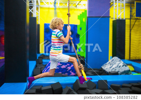 Child jumping in trampoline park. Bounce fun. 108385282