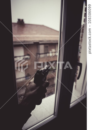 Gunman holding pistole in window 108386099