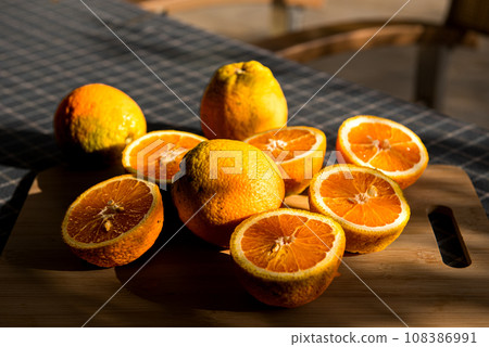 Large greek oranges, halved and ready to be squeezed for some golden, delicious juice. 108386991