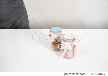 Making unicorn hot chocolate mix in drinking mason jar as a food gift. Making unicorn hot chocolate mix in drinking mason jar as a food gift. 108388827